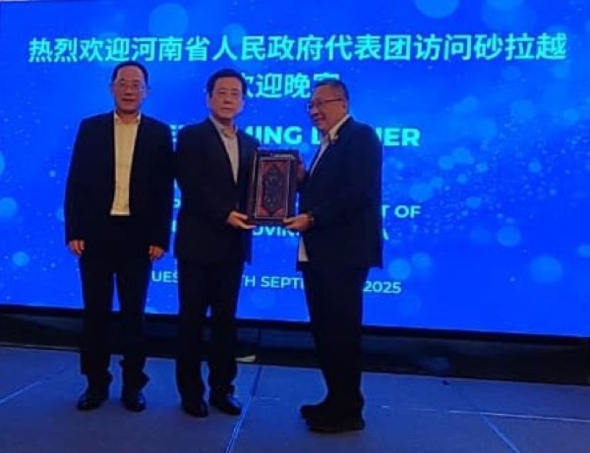 在中国驻古晋总领事邢伟平（左）的陪同下，古晋南市市长拿督黄鸿圣（右）赠送纪念品予河南省人民政府省长王凯时影。