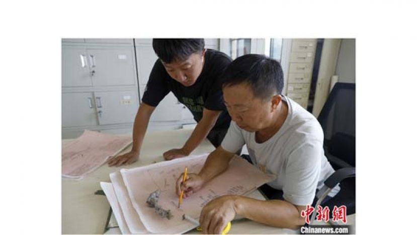 在云南省楚雄彝族自治州禄丰市恐龙化石保护研究中心，王涛（右）教导董启兴（左）绘制化石骨骼图。