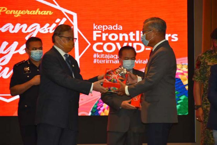 砂首长拿督巴丁宜阿邦佐哈里（左）移交开斋节与达雅节礼品盒予砂安全执法机构总监拿督蔡庆忠（右）。