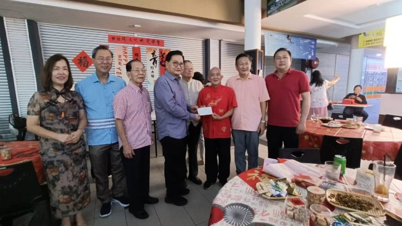 斯里阿曼华总会长拿督吴标生博士（左四）移交5000令吉拨款予古晋映画艺文社主席田招炎（右三），支持该设拍摄斯里阿曼历史视频的经费。