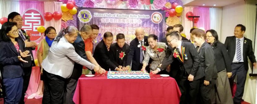 哥打圣淘沙狮子会十周年晚宴上，共切纪念蛋糕。