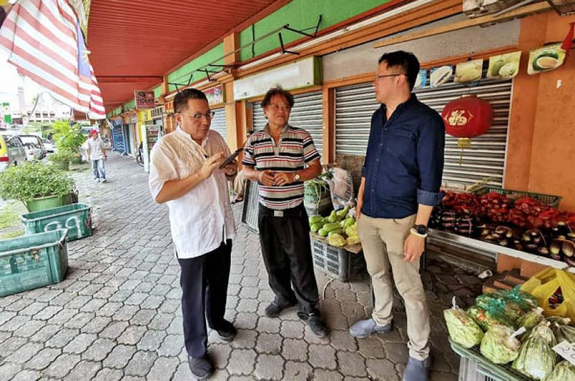 北市局行政委员拿督黄鸿圣（左）及砂人联党古晋支部署理主席黄廉欢（右）到Saujana Car Park底楼店铺向商家了解情况。
