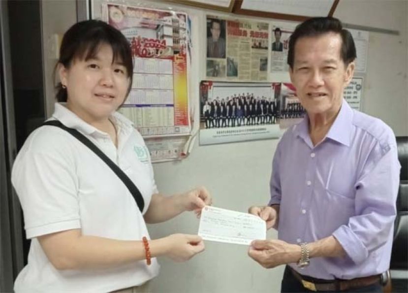 本固鲁陈兴枝（右）移交捐款予古晋传爱弱势福利机构负责人鲁玉珠。