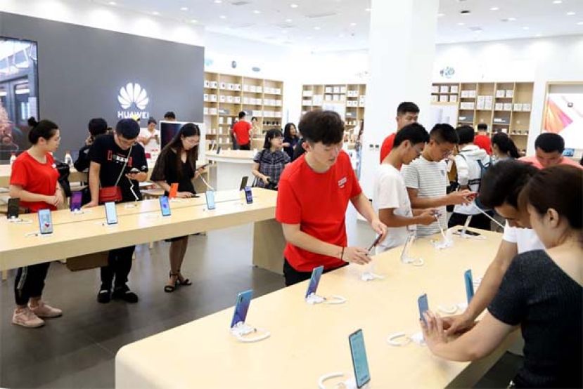 顾客们正在体验华为手机。