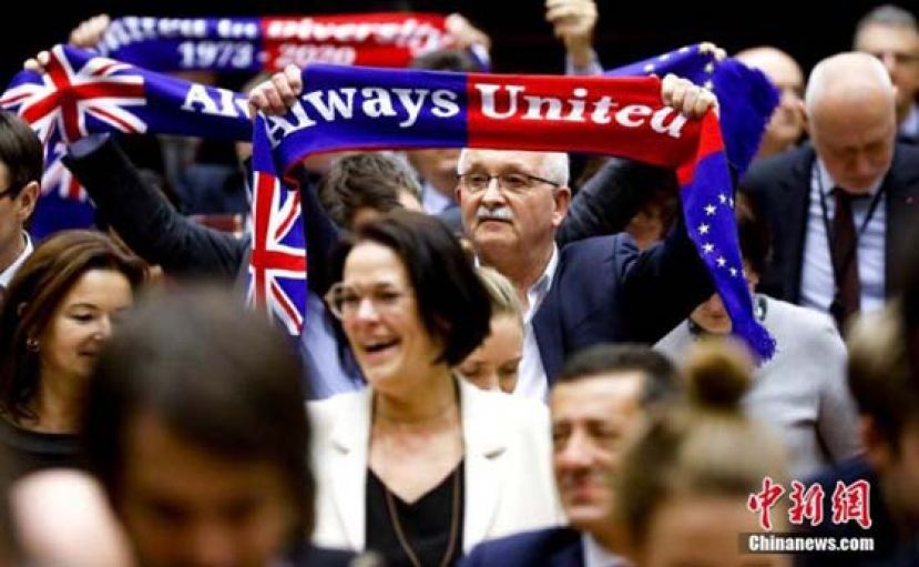 当地时间1月29日，欧洲议会批准“脱欧”协议。图为投票结束后，在场议员高举“永远团结”旗帜。