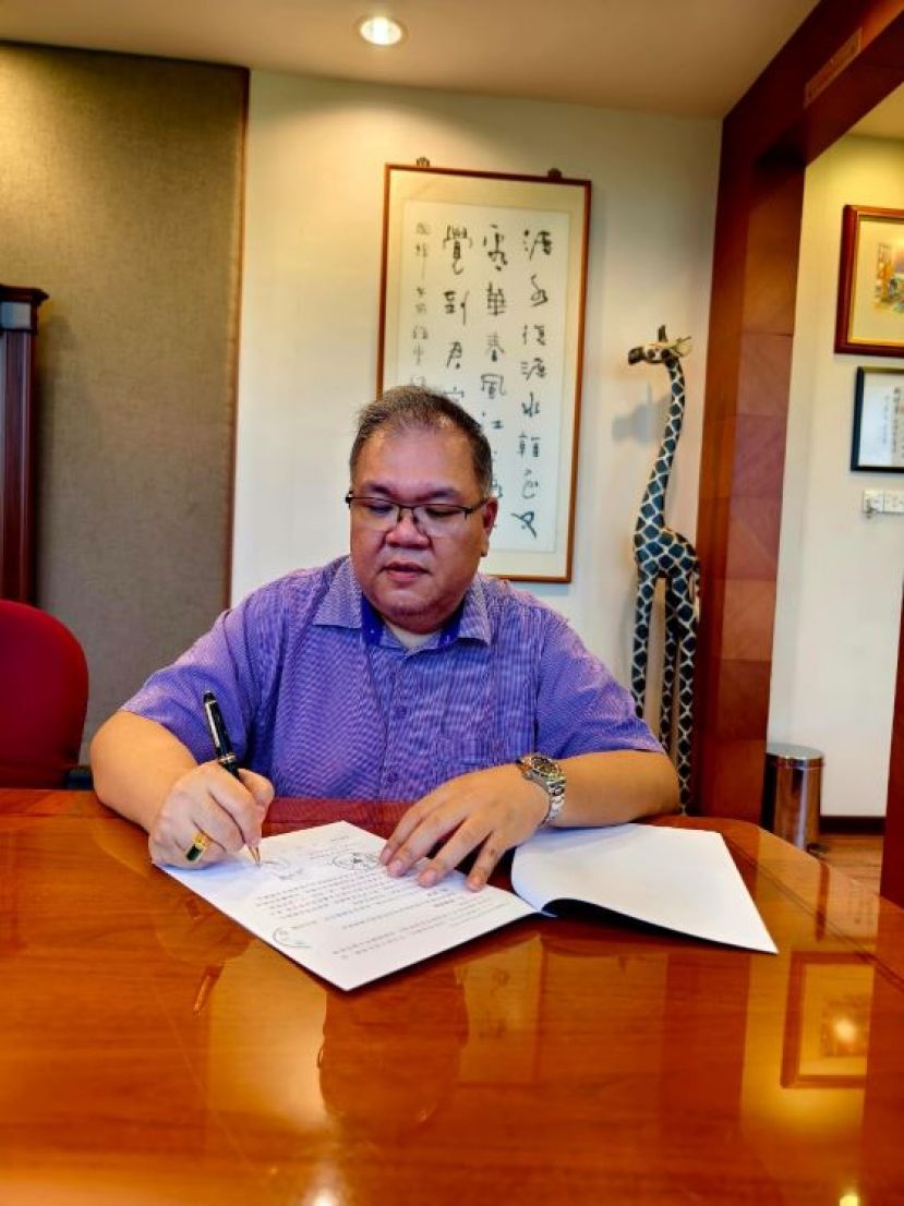 中国教育与文化考察团领头人拿督黄国辉在签署合作协议书时影。