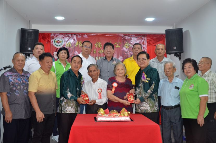 吴标生（右3）及黄天明（左3）分别颁赠红包予许赛莺及黄祯灼。