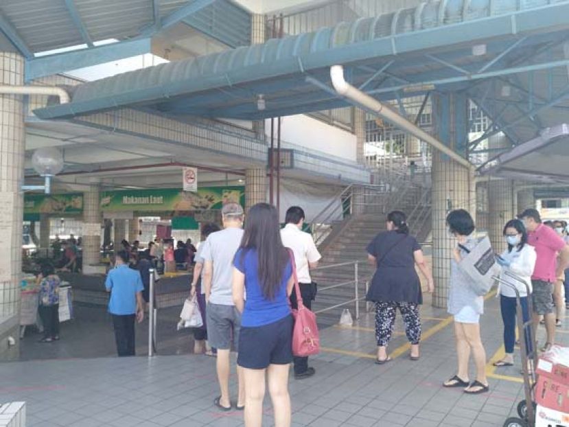 三哩小贩市场，民众排队等候进入购物。右边临时售卖土著农产品区空荡荡。