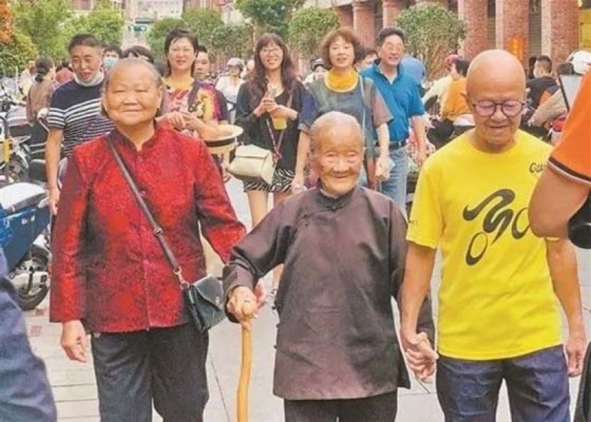 110岁妈妈牵80岁儿逛街,羡煞众人街头追寿星求合照。