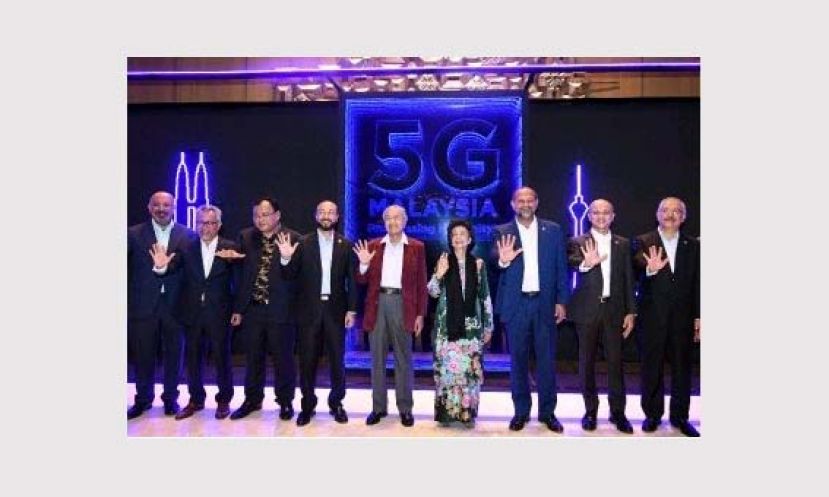 首相敦马哈迪(左5)与一众嘉宾比出象征“5G”的手势，标志浮罗交怡的5G大马示范项目正式启动。