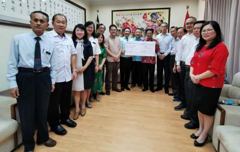 古晋中华小学校董会主席王长福（左8）在古晋中华小学校董会署理主席蔡文铎（左9）及校董和校长见证下移交模拟支票予中国驻古晋总领事程广中，右6为中国驻古晋总领事张