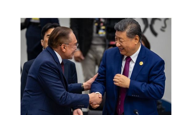 首相安华与中国国家主席习近平在韩国亲切握手交谈(档案图)。