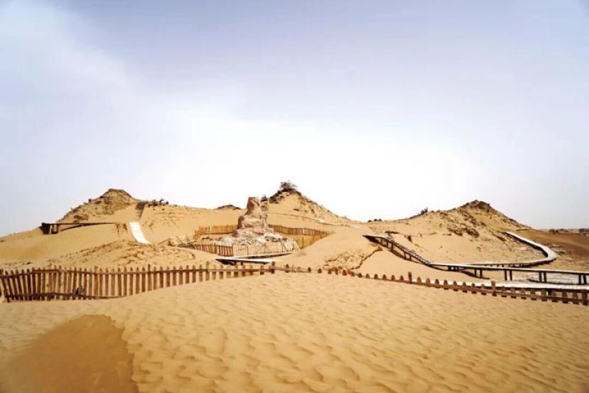 尼雅遗址中心建筑佛塔，坐落于三座沙丘之前。