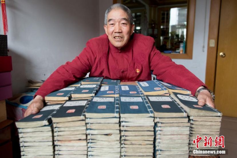 图示：张喜才老人在家中整理他手抄的小楷体四大名著。