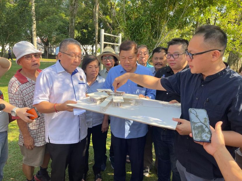 古晋南市市长拿督黄鸿圣（左一）以及副市长再迪苏海迪（左二）和市议员等在观赏即将落成的辉盛公园单层社区中心模型时摄。