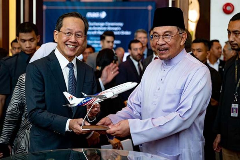 ●大马航空集团董事经理拿督依兹汉（左）象征性移交马航飞机模型给首相安华。