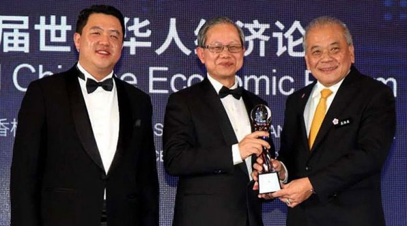 吴添泉（右）从李文材手中接领世界华人杰出终身成就奖（华人社团团结领导）奖。左为；谢泉勇。