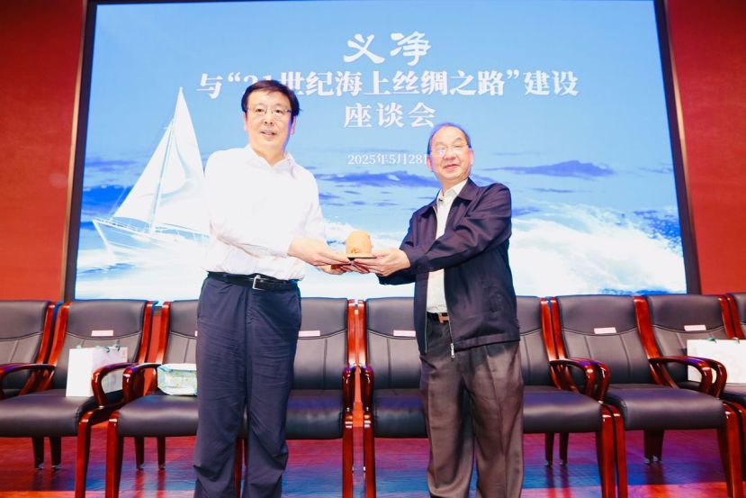 白山（左一）在座谈会后，赠送记念品于吴恒灿。