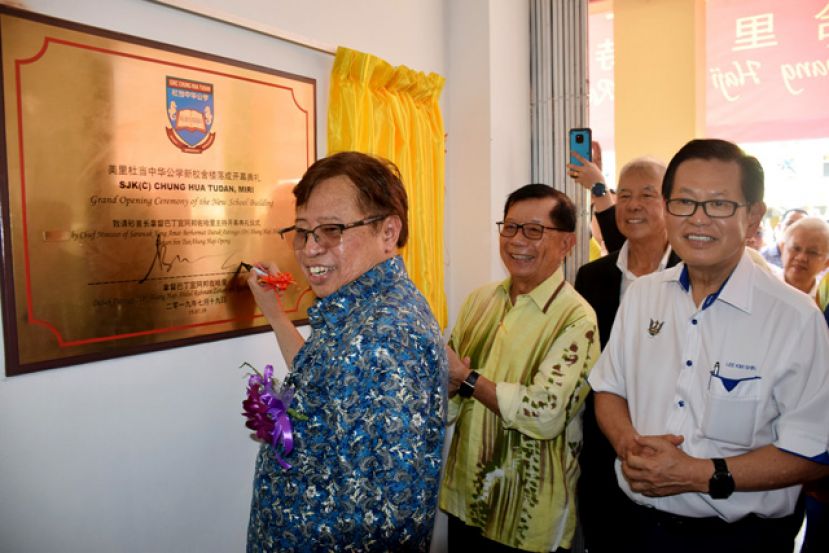 首长阿邦佐在陈康南、陈超耀及李景胜等董事陪同下为杜当中公新校舍大楼主持落成，并在牌匾上签名。