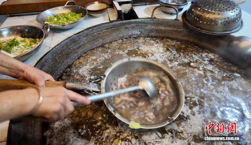 苏稽古镇内，跷脚牛肉店工作人员正在大汤锅内烫熟牛肉。