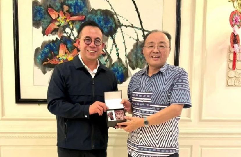 沈志强（左）赠送领带及口袋巾套装给欧阳玉靖。