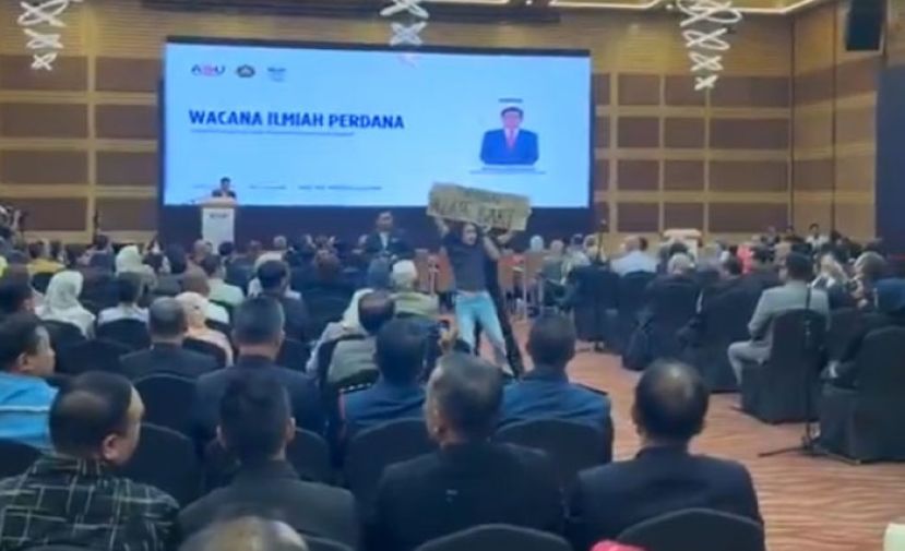 阿占巴基演讲中途遭闹场　青年举牌抗议被带离