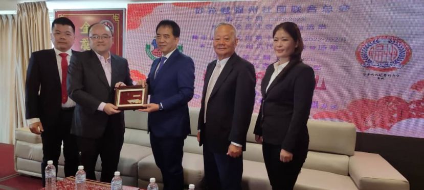 在会员大会开幕礼上，会长甲必丹刘思乐（左2）移交纪念品予主宾拿督许赞麒时影。右起为砂福妇女组主人黄小萍以及永久荣誉会长拿督斯里刘久健。左为青年团团长郭可利。