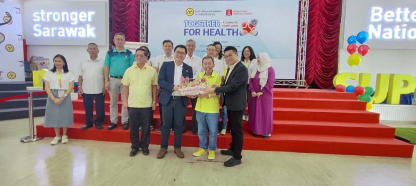 砂人联党古晋支部青年团团长黄笃荣（左二）以及古晋金宝林医疗中心首席执行元陈庆丰的代表吴其洲（右）一起赠送纪念品予主宾拿督阿玛沈桂贤时影。左一为天猛公拿督陈如飞。