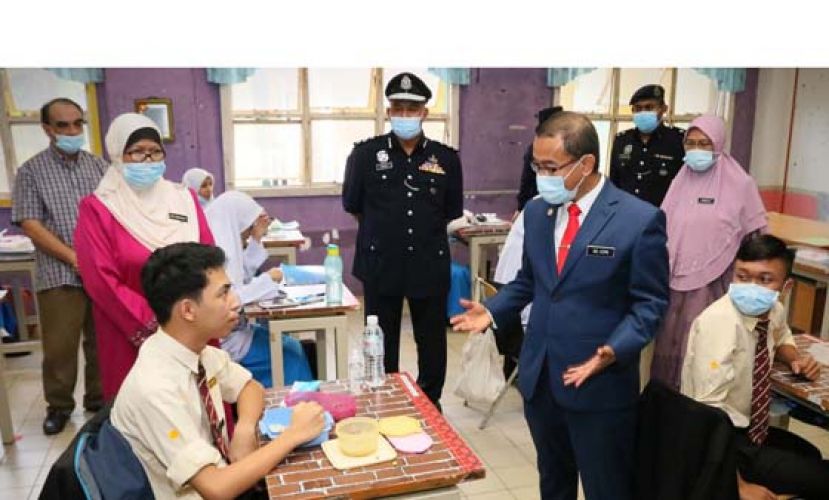 诺阿兹米(前排中)了解学校复课,学生在课室内用餐情况。