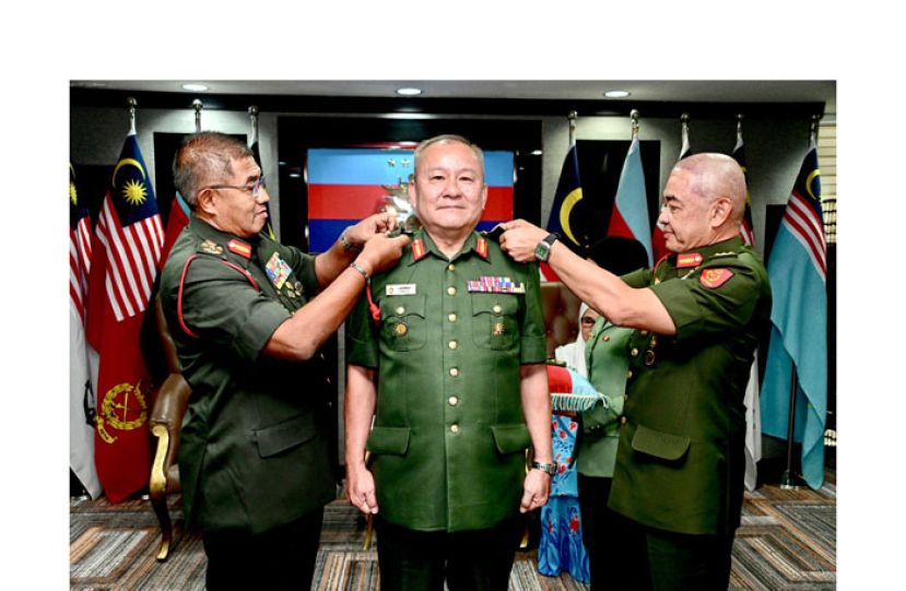 大马陆军司令丹斯里莫哈末尼占(左)与陆军参谋长丹斯里哈菲祖丁(右)为林英成中将（中）主持晋升仪式。