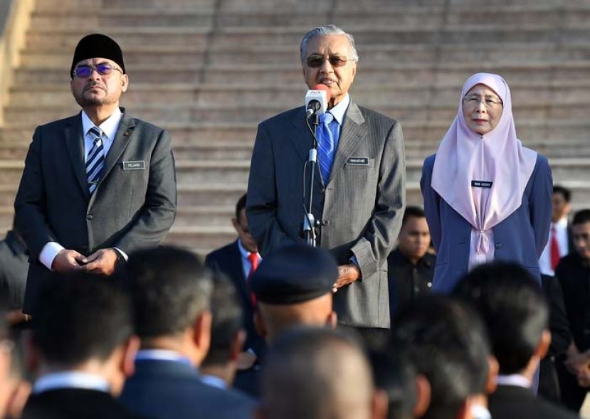 图：首相敦马哈迪(中)在首相署常月集会上致词，右为副首相拿督斯里旺阿兹莎和首相署部长慕查希(左)。