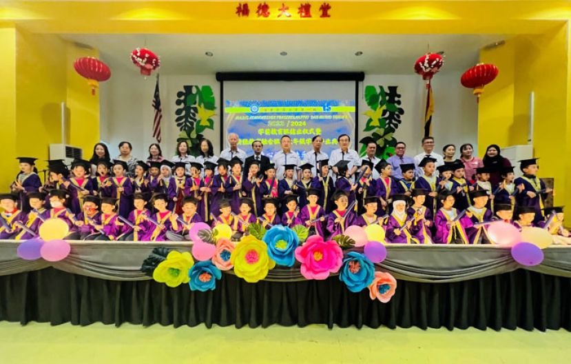 古晋中华小学第一校校董、行政人员与学前教育班结业学生合影。后排左起：特教融合班主任张洁怡、学生事务主任陈彩芳、行政主任黄彩鳳、校董张慧娇、视察江丽丽、代秘书长林光钟、一小校长李美发、校董会主席拿督蔡文铎律师、一小校董副主席梁柏就、三校校董副主席郑文发、监学李河龙、校董萧家宝督学、课外活动主任方秉发。