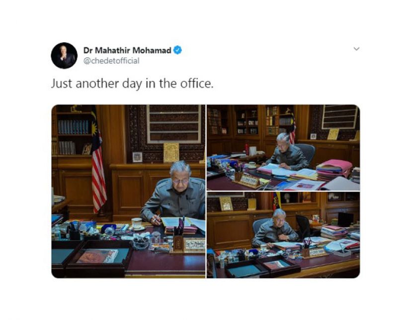 马哈迪在办公桌前，聚精会神批改文件。