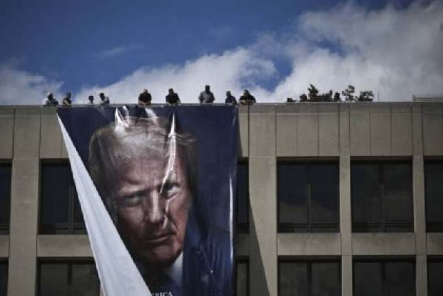 ●美国联邦上诉法院29日裁定，总统特朗普无权单方面大规模徵收关税，其贸易保护主义政策在法律基础上并不成立。图中特朗普支持者在建筑物上悬挂其海报。