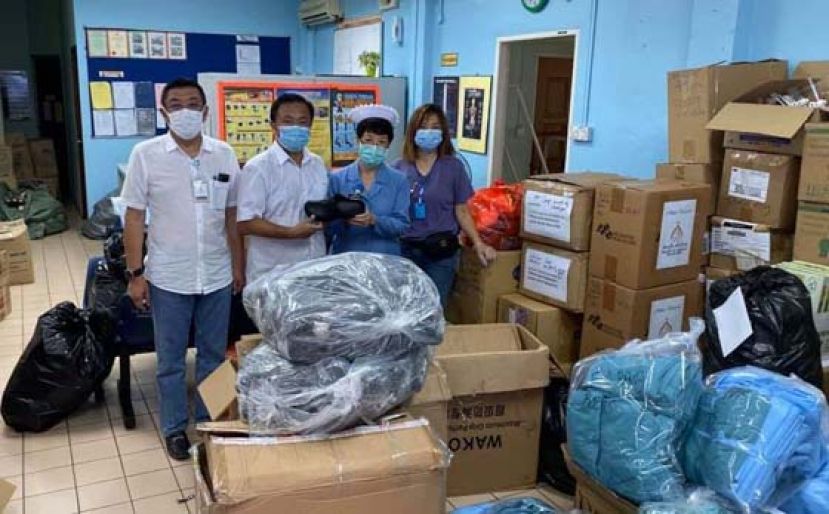 《华总紧急救灾组》主任甲必丹陈国璋（左2）移交胶鞋及N95口罩予古晋砂拉越中央医院医务人员时影。左为会长拿督黄良杰、右为张慧娇。
