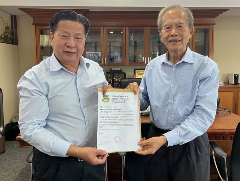  亚洲中医技职学院院长江宗兴（左）移交任多届学员毕业典礼贵宾函予砂医总名誉顾问拿督张泰卿。