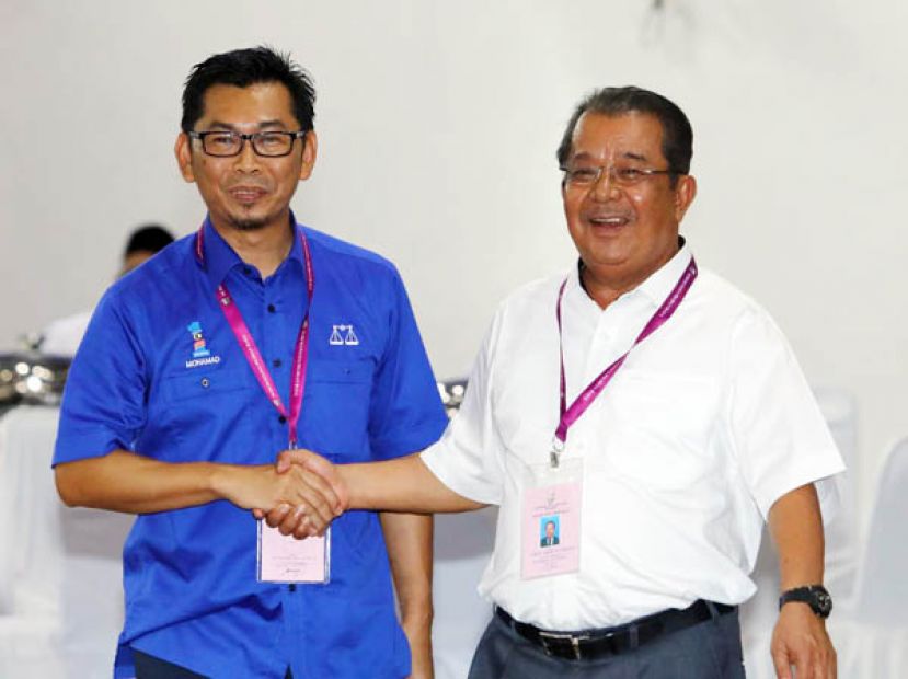 国阵巫统候选人莫哈末阿拉敏(左)与沙巴民兴党候选人卡林布章(右)先礼后兵，互相握手。