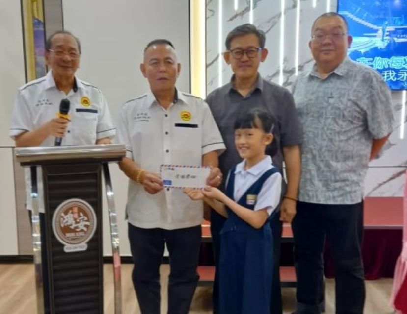 古晋老巴刹民众联谊会会长甲必丹林传政（左2）颁发会员子女学业优良奖励金。右起为林宗利、薛华东；左是孙守生。