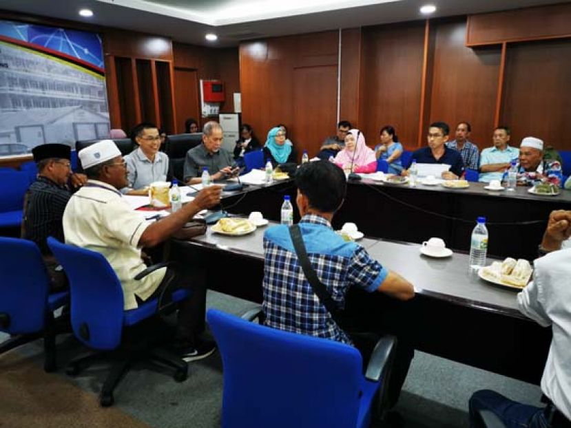 拿督斯里旺朱乃迪（中）与甘榜代表与砂公共工程局官员开会讨论。