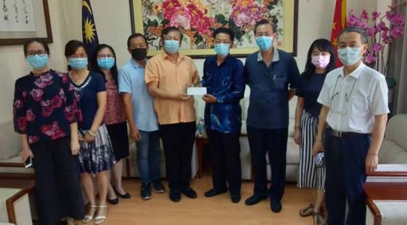 中国驻古晋总领事程广中（右四）移交5万令吉予古晋中华小学校董会主席拿督王长福（左五）。