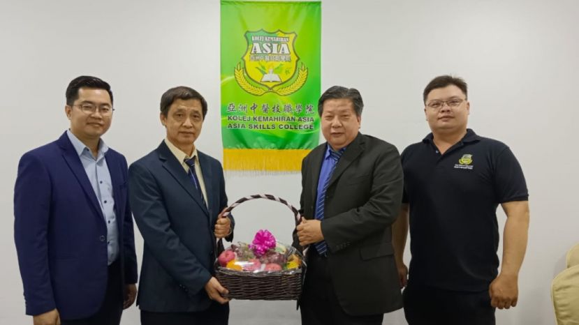 砂医总医学顾问林友镁（左2）由砂医总会长兼亚洲中医技职学院院长江宗兴（左3）手中接过水果礼蓝。左一为学院主任江邦忠：右一是学院助教陈永同理疗师。