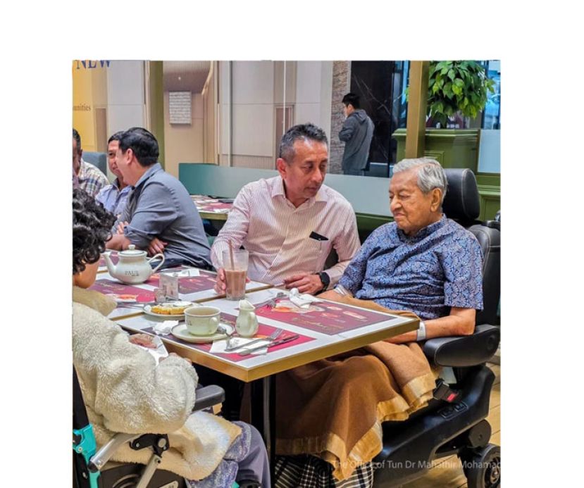 久未露面的马哈迪坐在轮椅上享用冷饮。