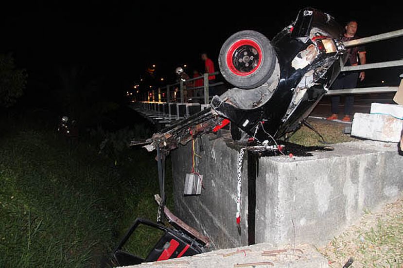 轿车失控撞护栏后断成两截，一截挂在路旁护栏杆上。