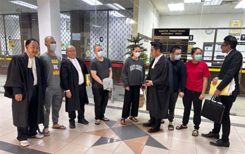 获得无罪释放的5名男女和辩护律师交谈时影。
