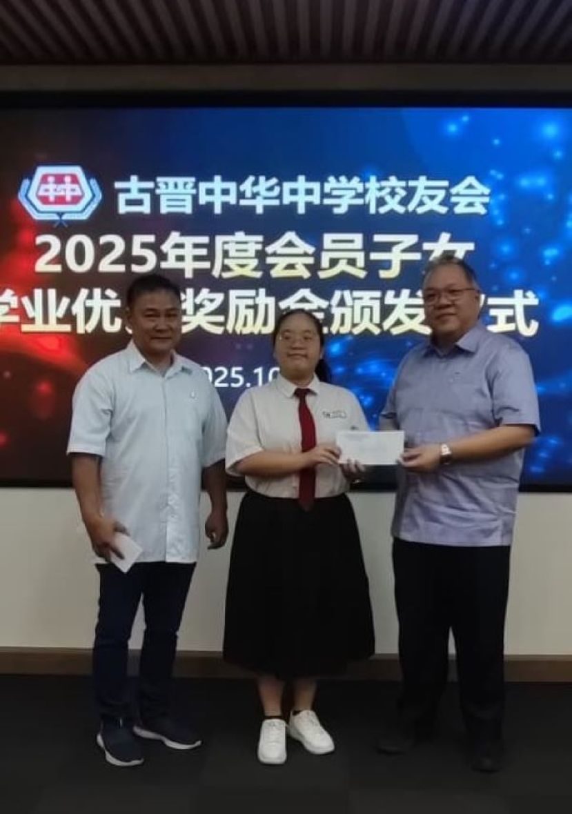 古晋中中校友会会长拿督黄国辉（右）颁发奖励金予官茹恩时影。左为教育组主任吴泽源。