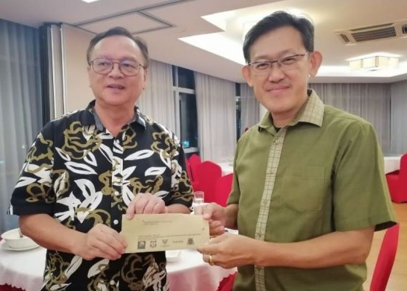 拿督罗克强（左）由薛华东手中接过婆罗洲妈祖文化节活动贵宾邀请函。