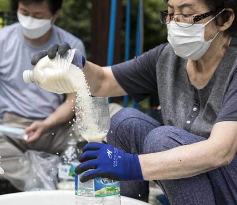 脱北者把大米倒入胶瓶。