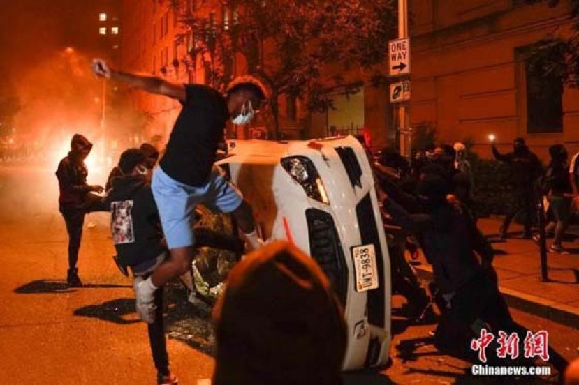 资料图：在美国首都华盛顿白宫附近，示威者将警车推翻砸烂。