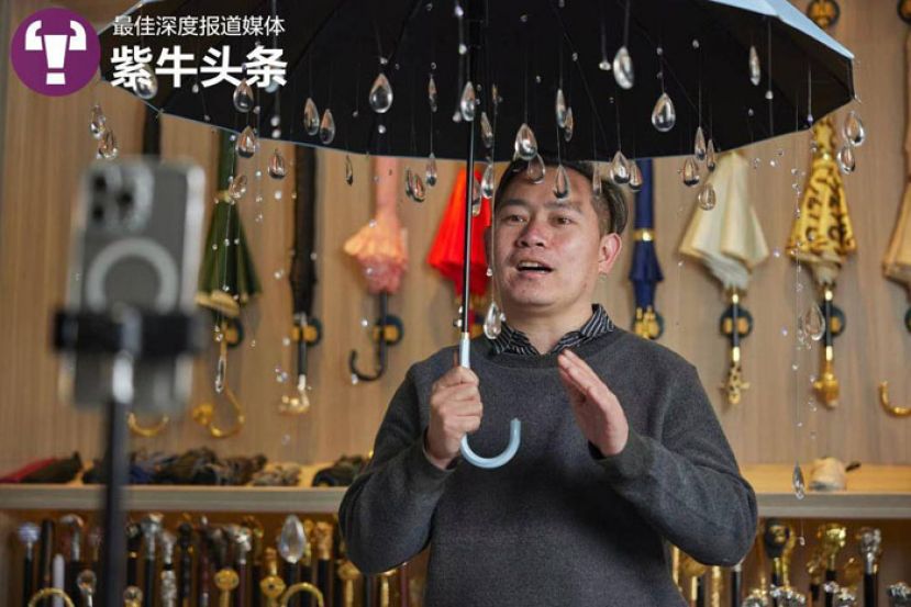 雷鹏琳举着自家生产的稀奇古怪的伞。