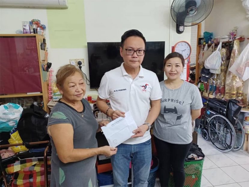 砂人联党公共投诉局主任符祥威（中）把5000令吉来自38爱心慈善基金会的现金移交给蔡伟雄的母亲，右一为蔡惠珍。